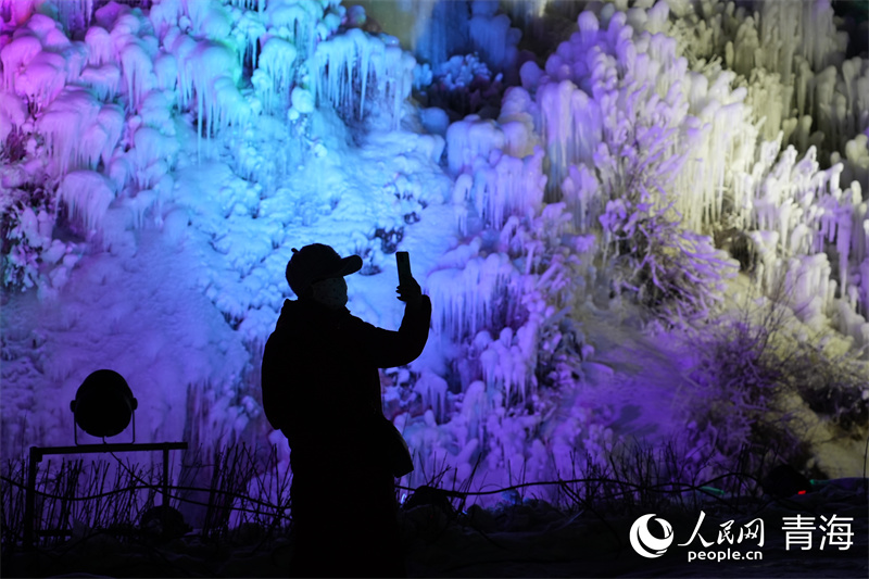 游客拍照打卡燈光下的美妙雪景。人民網(wǎng) 馬可欣攝