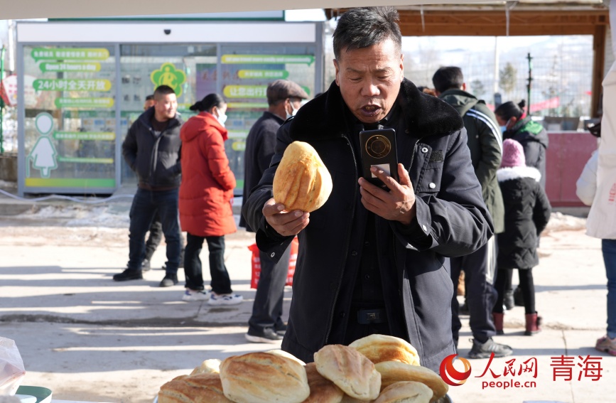 年貨集市上當(dāng)?shù)厝罕娋€上售賣饃饃。人民網(wǎng)記者 甘海瓊攝