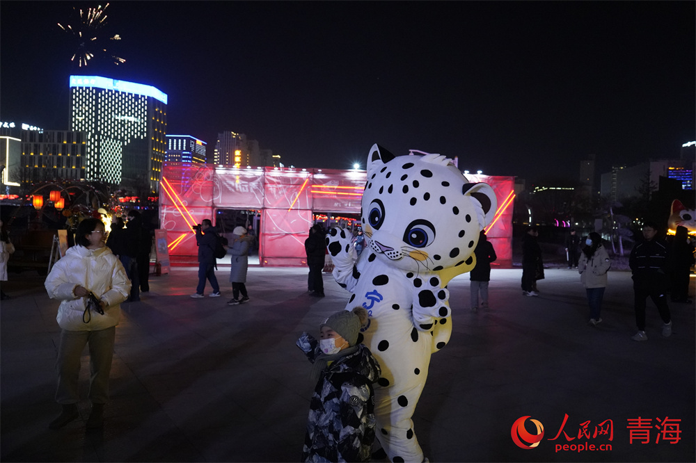 市民與雪豹玩偶“寧萌”合照。人民網(wǎng) 馬可欣攝